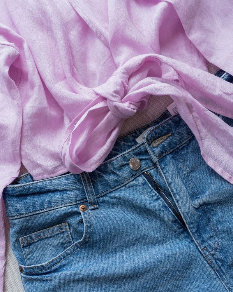 a pair of jeans with a pink scarf tied around the waist a pair of jeans with a pink scarf tied around the waist