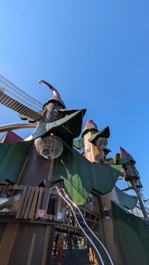 Left photo shows a toddler pressing a doorbell on a wooden cottage, the right photo is of Lilidorei, a fantasy-inspired play structure with ladders, bridges and slides.