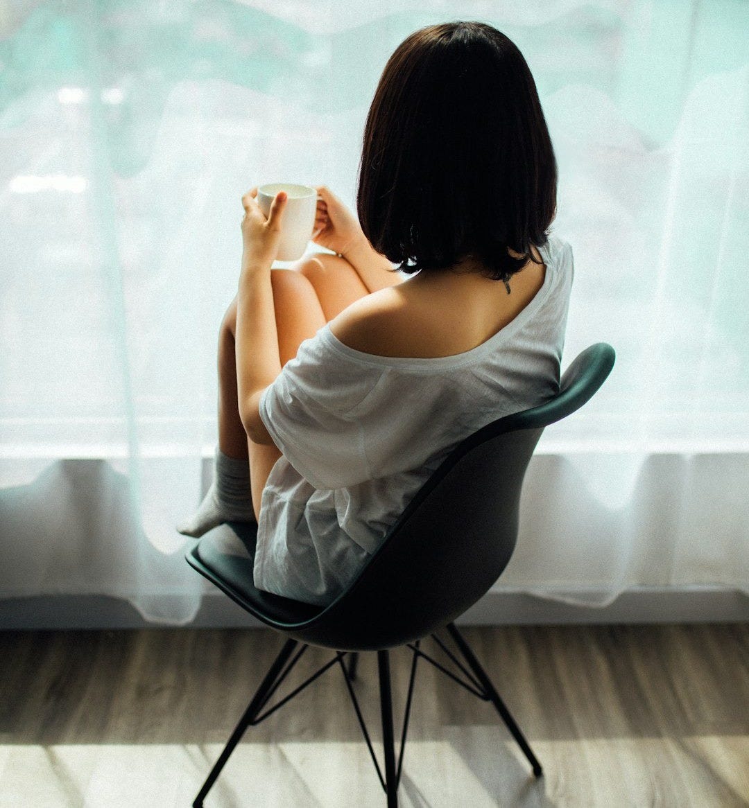 woman in white tank top sitting on chair woman in white tank top sitting on chair