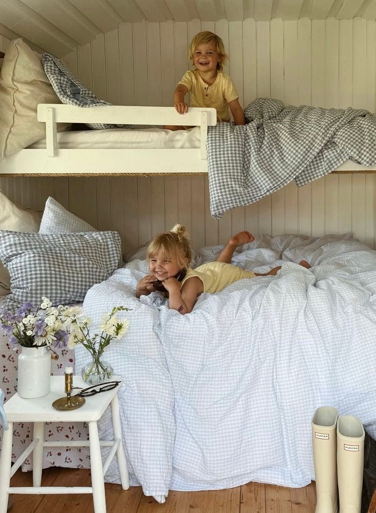 This may contain: two children laying on top of bunk beds This may contain: two children laying on top of bunk beds