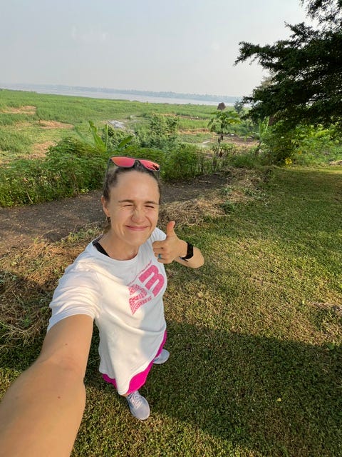 Runner gives a thumbs-up next to lush vegetation along the banks of the wide Congo River