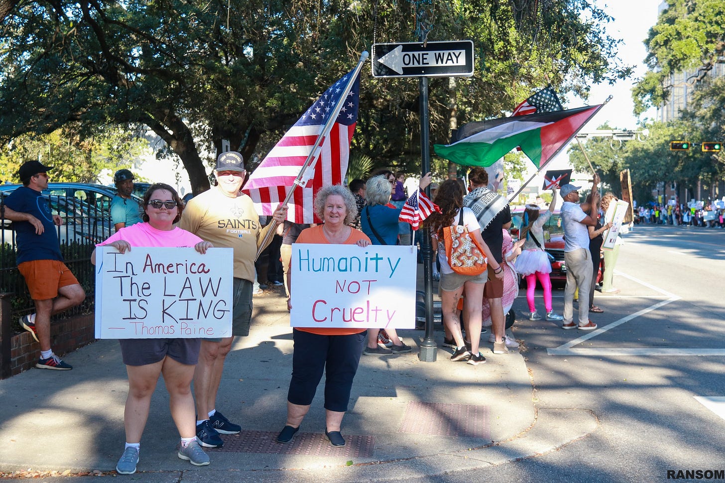 May be an image of crowd and text that says 'ONE ONEWAY WAY 三 SAINTSA POOTW OA In America The LAW IS KING Thamas rOli ThamasFaine 0 ne Humanity NOT Cruelty'