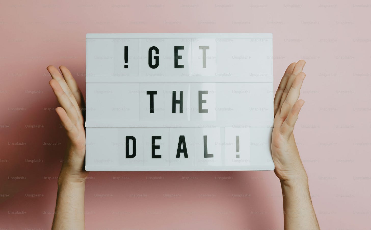 a person holding up a sign that says i get the deal