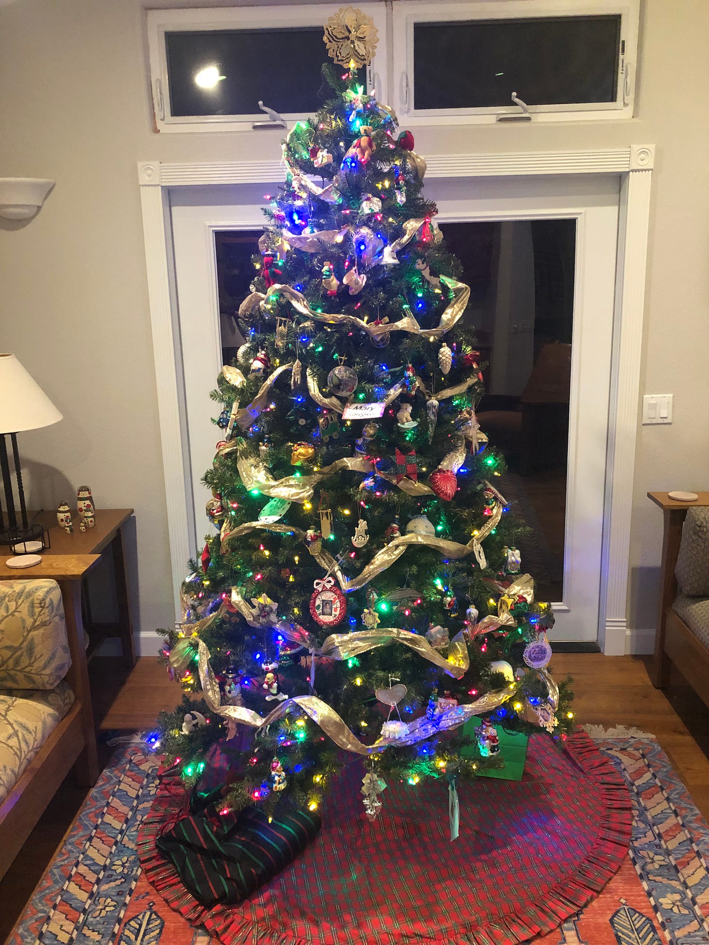 A Christmas tree with multi-colored lights, a variety of ornaments (including handmade) and gold garland. A Christmas tree with multi-colored lights, a variety of ornaments (including handmade) and gold garland.