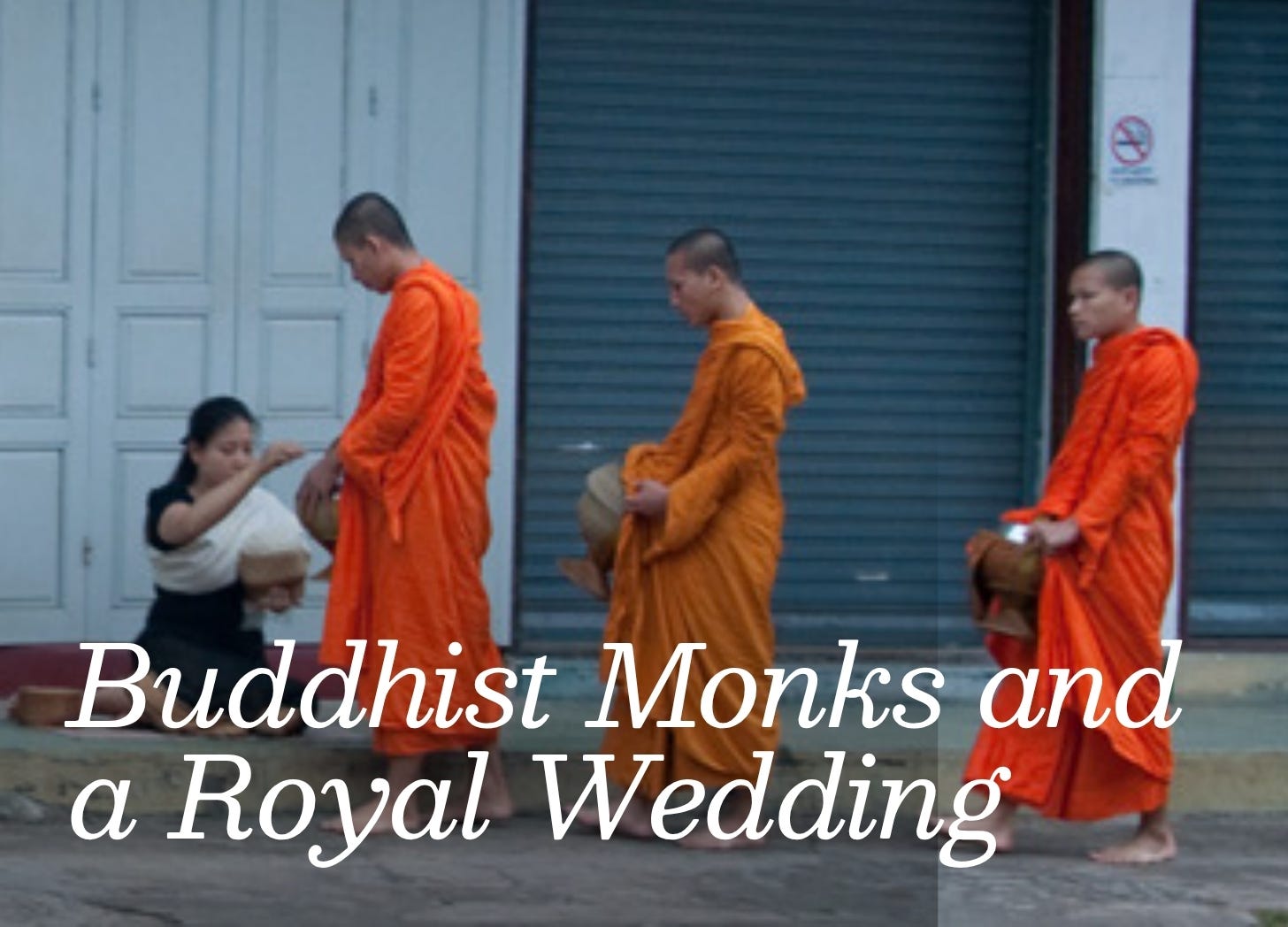 A line of orange-robed monks participating in an alms-giving ceremony on the main street on Luang Prabang.