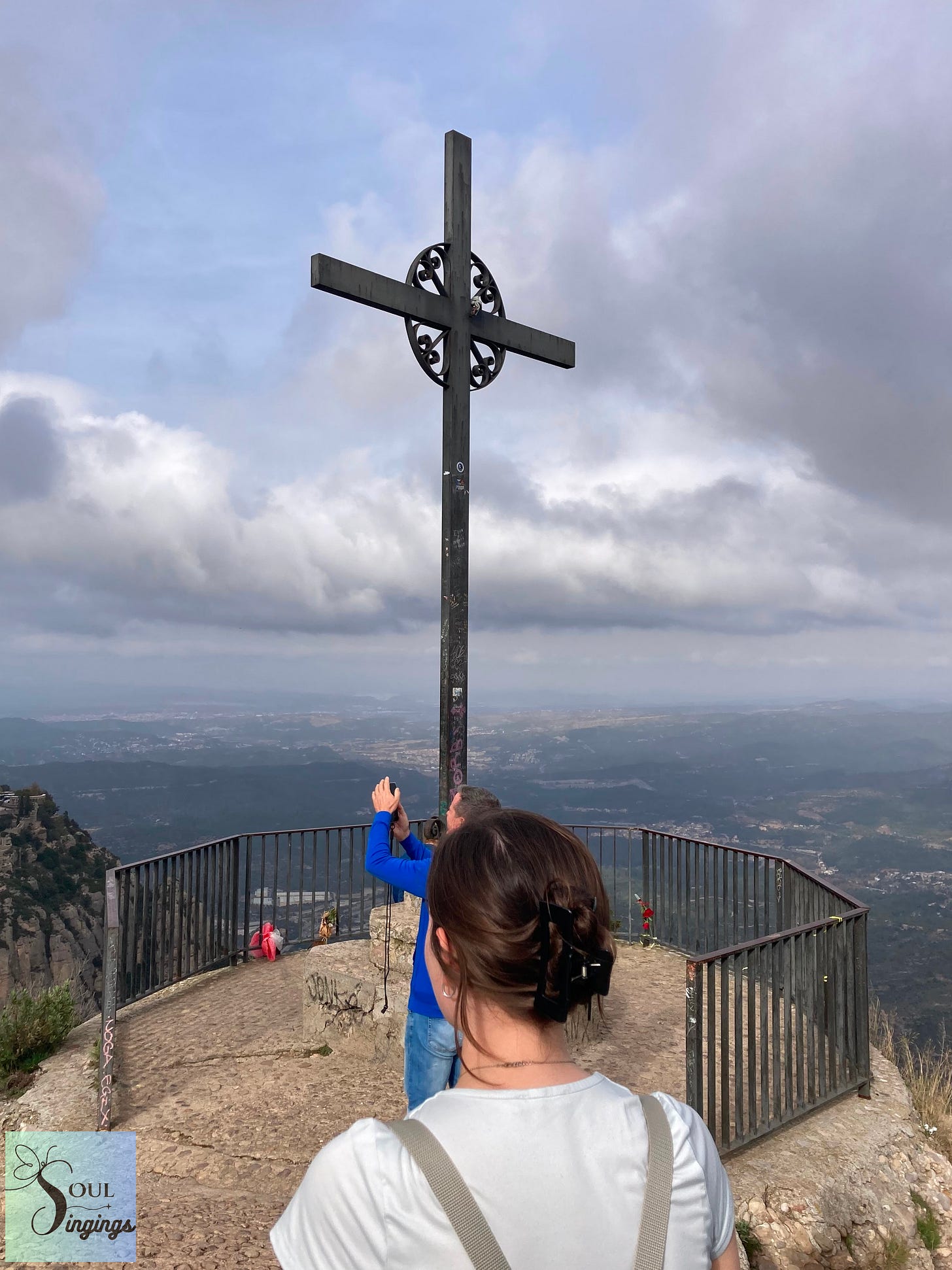 Tears in the Tinsel, 2--girl looking at a metal cross on a mountaintop