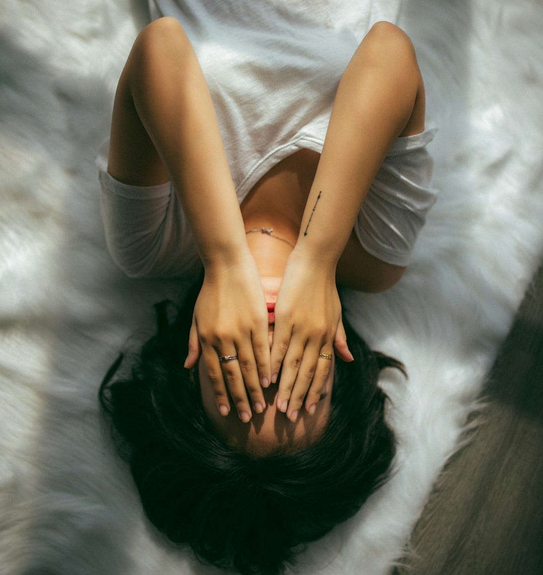 a woman holds her hands over her face a woman holds her hands over her face