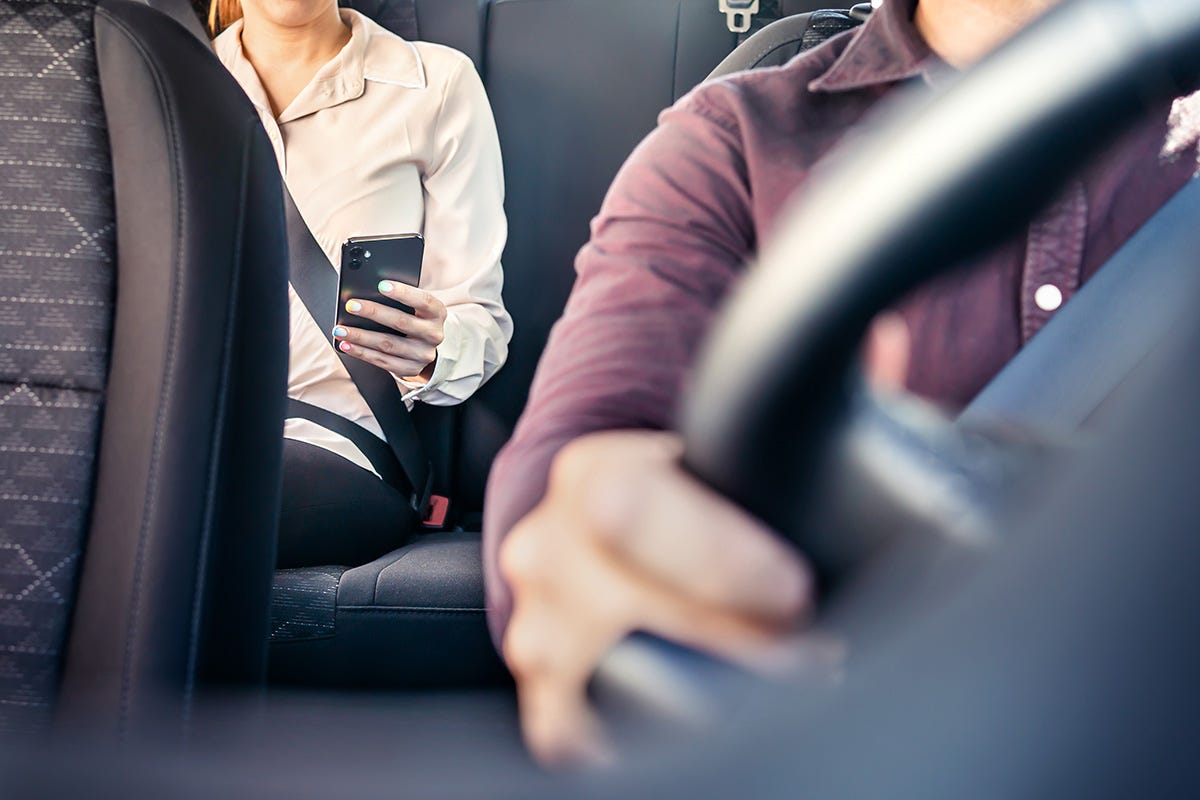 A person scrolling on their phone in a cab. 
