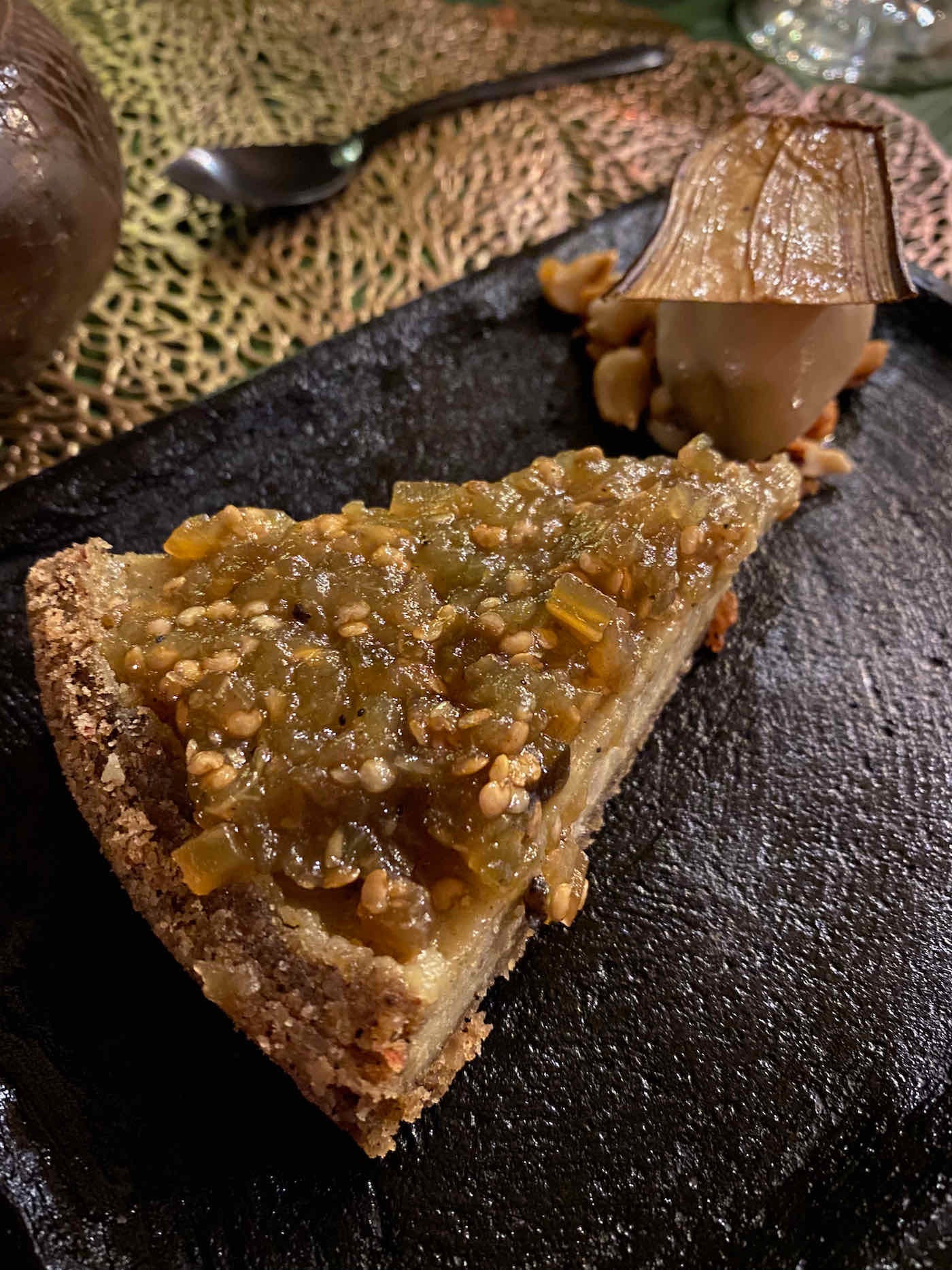 A slice of eggplant cheesecake with a quenelle of coffee ice cream on a stone plate