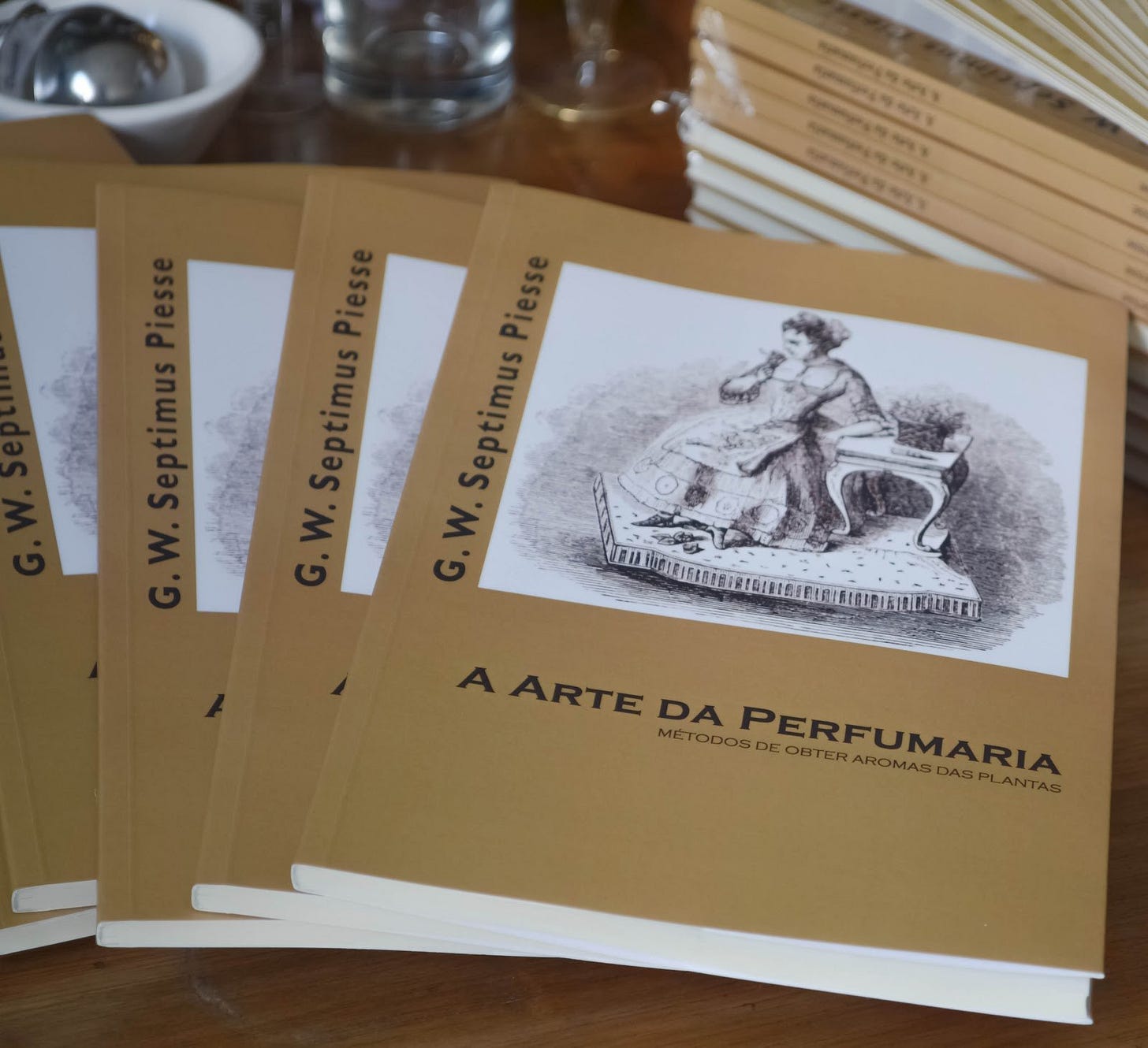 A stack of Portuguese editions of A Arte da Perfumaria by G.W. Septimus Piesse, translated and published by Editora Laszlo