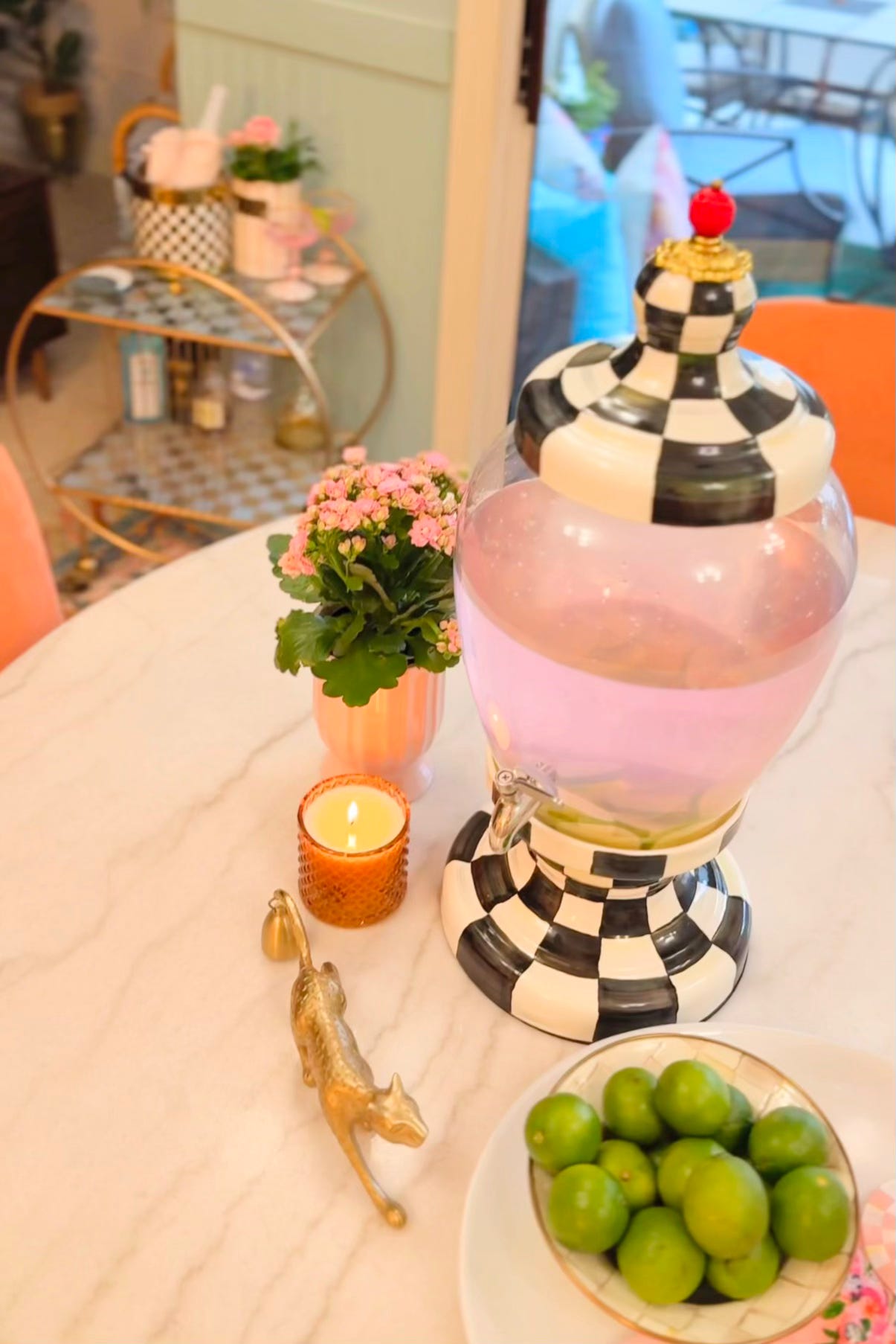 MacKenzie-Childs Courtly Check Beverage Hostess serving a pink citrus drink with fresh lime slices in Shaunda Necole's Las Vegas kitchen. Styled for The Soul Food Pot® to inspire Southern hospitality and everyday entertaining.