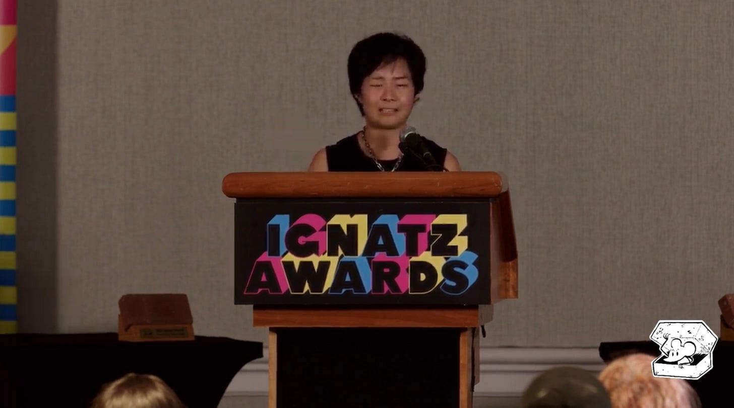 standing at the Ignatz Awards podium, crying