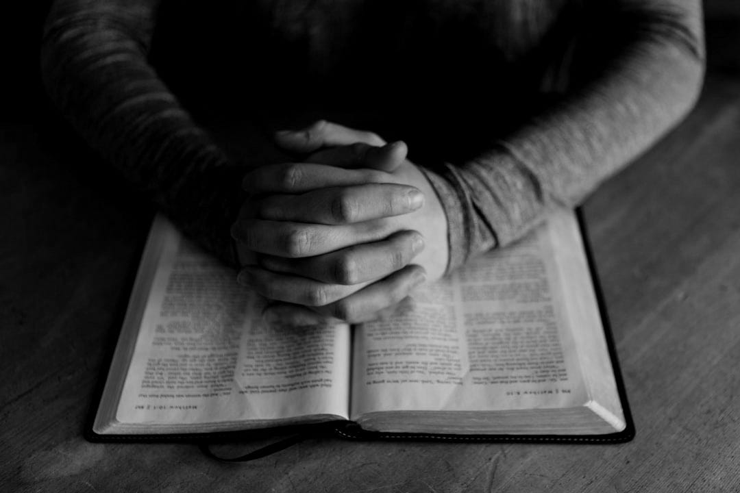 man holding his hands on open book