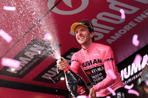 Simon Yates celebrates on the podium after stage 20