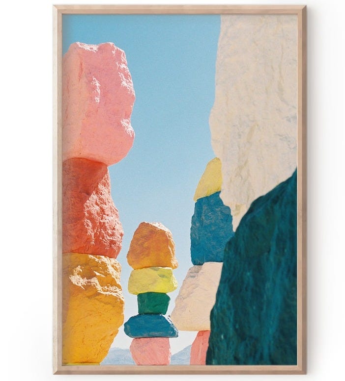 May include: A framed photograph of a colorful rock formation in the desert. The rocks are stacked on top of each other and painted in various colors, including pink, orange, yellow, green, and blue. The sky is a clear blue and there are other rocks in the background. May include: A framed photograph of a colorful rock formation in the desert. The rocks are stacked on top of each other and painted in various colors, including pink, orange, yellow, green, and blue. The sky is a clear blue and there are other rocks in the background.
