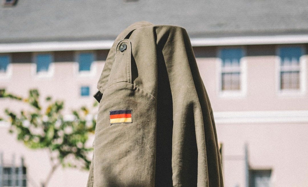 gray button-up jacket on brown rack gray button-up jacket on brown rack