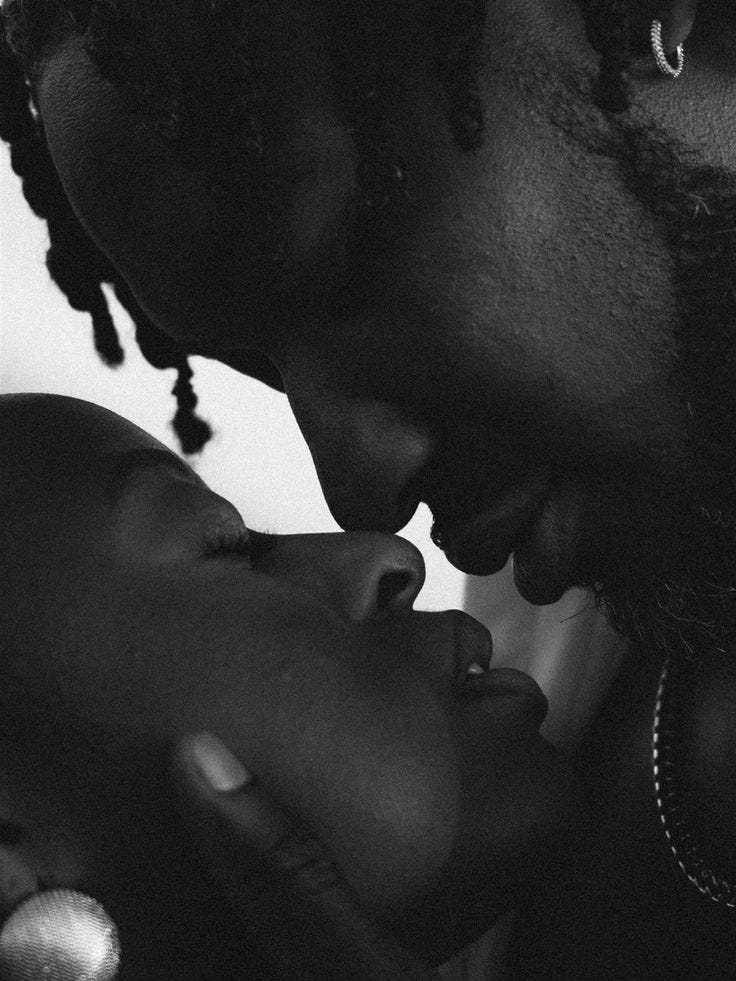 This may contain: a black and white photo of a man kissing a woman's forehead with her eyes closed