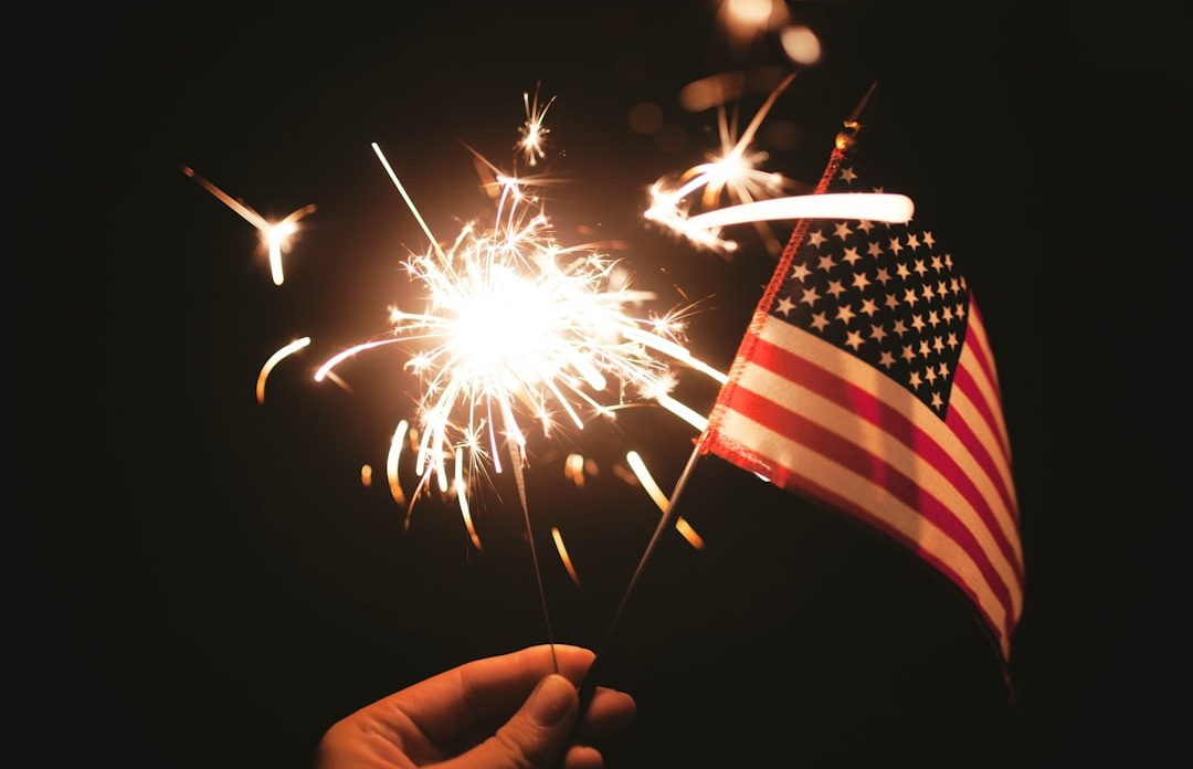 time lapse photography of sparkler and U.S.A flag let