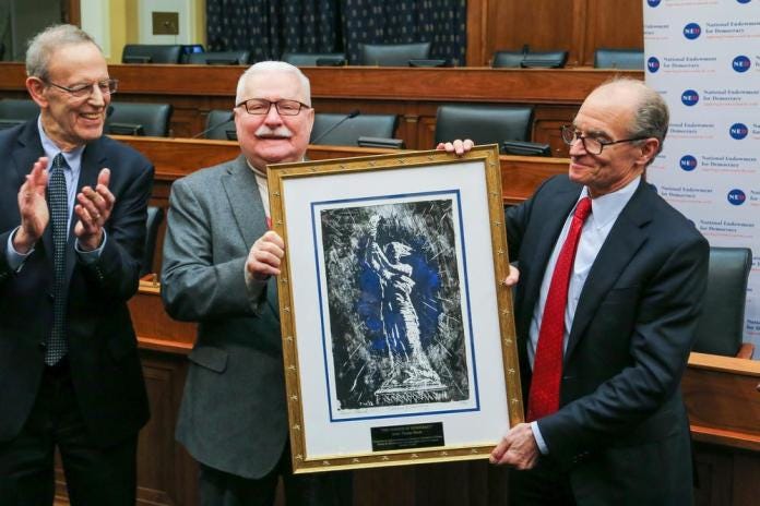 A group of men holding a framed picture

Description automatically generated with medium confidence