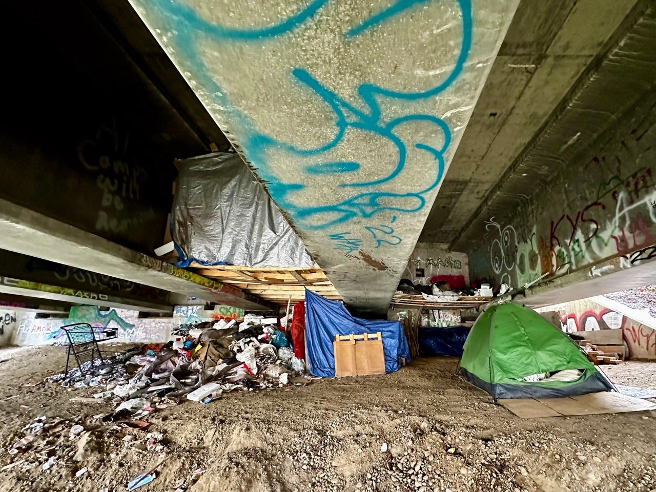 A underpass with a tent and graffiti

Description automatically generated