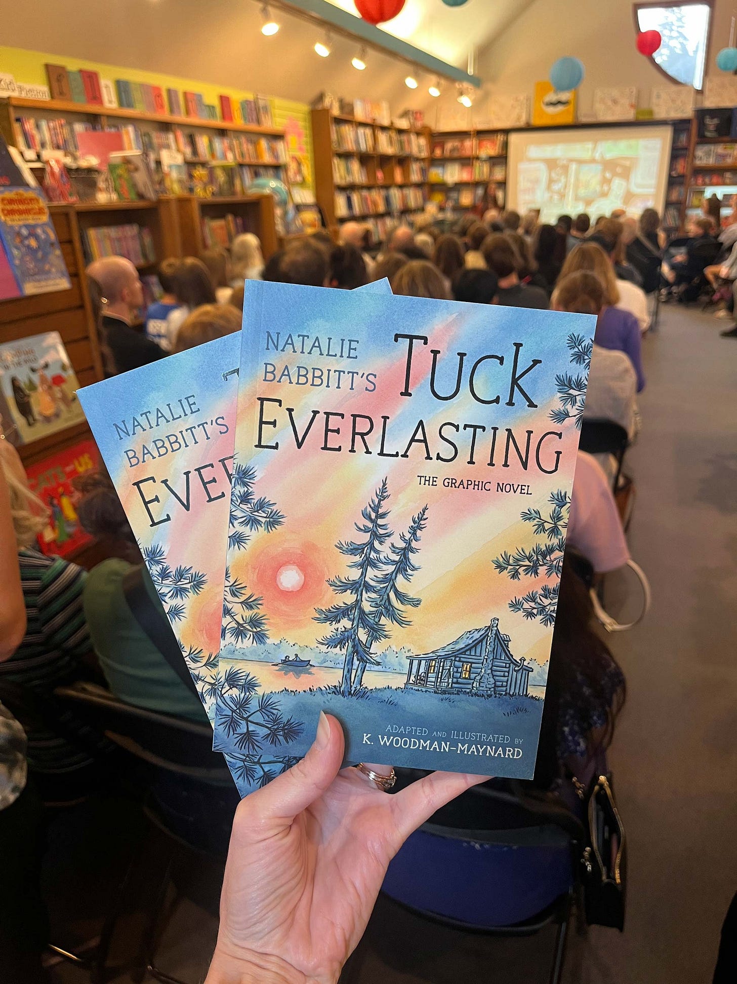 Graphic novelist K. Woodman-Maynard holding her published copies of Tuck Everlasting at her book launch back in September. 