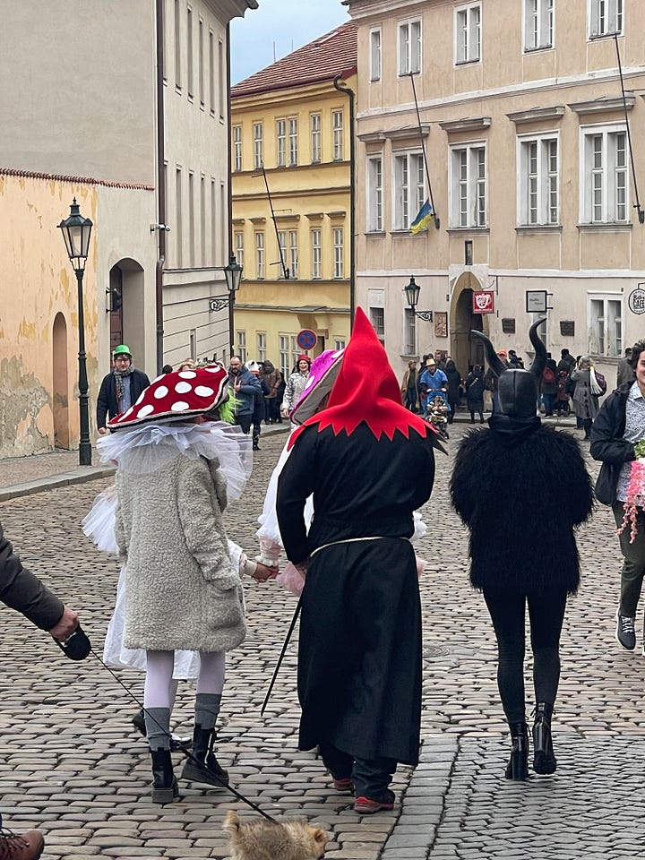 A woman offers cups of svařák (Czech mulled wine) to strangers during the Masopust procession.