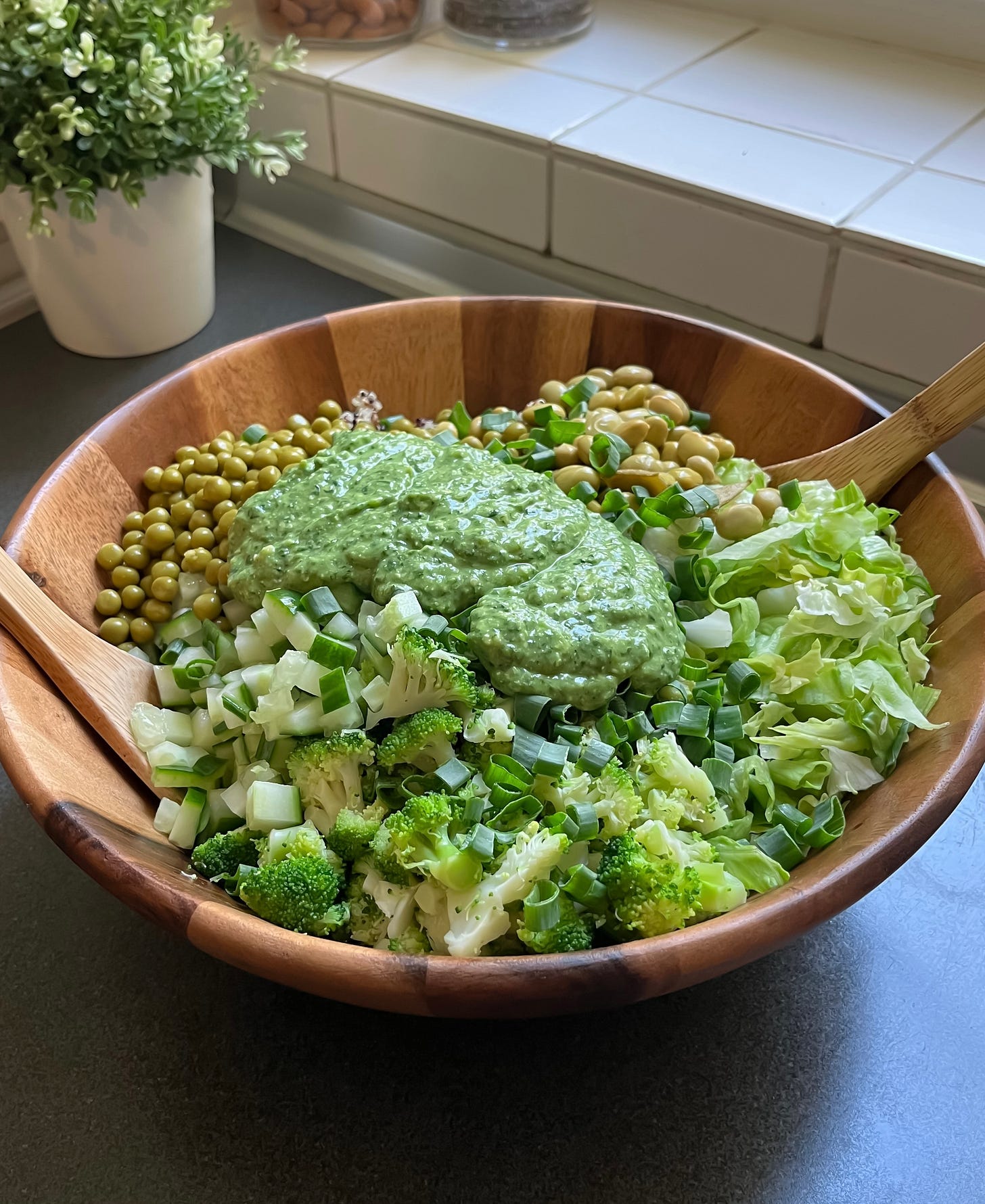 Close-up of vibrant green goddess salad with a drizzle of homemade avocado-herb dressing.