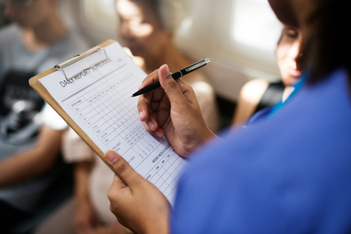 A healthcare professional holding a clinical intake form, symbolizing the institutional history of prioritizing professional authority over caregiver reports.