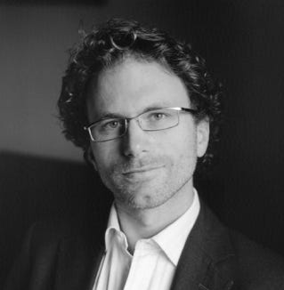 A person wearing glasses and a suit

AI-generated content may be incorrect.