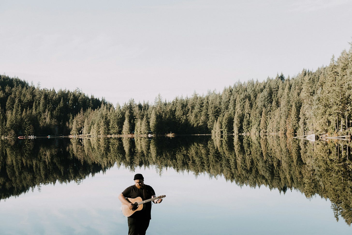 Un musicista suona la chitarra immerso in un paesaggio naturale Un musicista suona la chitarra immerso in un paesaggio naturale