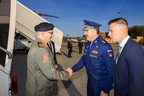 Haftar (majtas) shtrëngon duart me zëvendësministrin rus të Mbrojtjes Yunus-bek Yevkurov në një aeroport ushtarak në Moskë (26 shtator 2023), si dhe shfaqet në takime të ndara me presidentin rus Vladimir Putin dhe ministrin e Jashtëm Sergei Lavrov—pamje që ilustrojnë afërsinë e tij me qendrën politike dhe të sigurisë së Rusisë. (Burimi: faqja në Facebook e Shtabit të Përgjithshëm të vetëshpallur të “Ushtrisë Kombëtare Libiane” / AFP; dhe fotografi nga takime zyrtare në Moskë.)