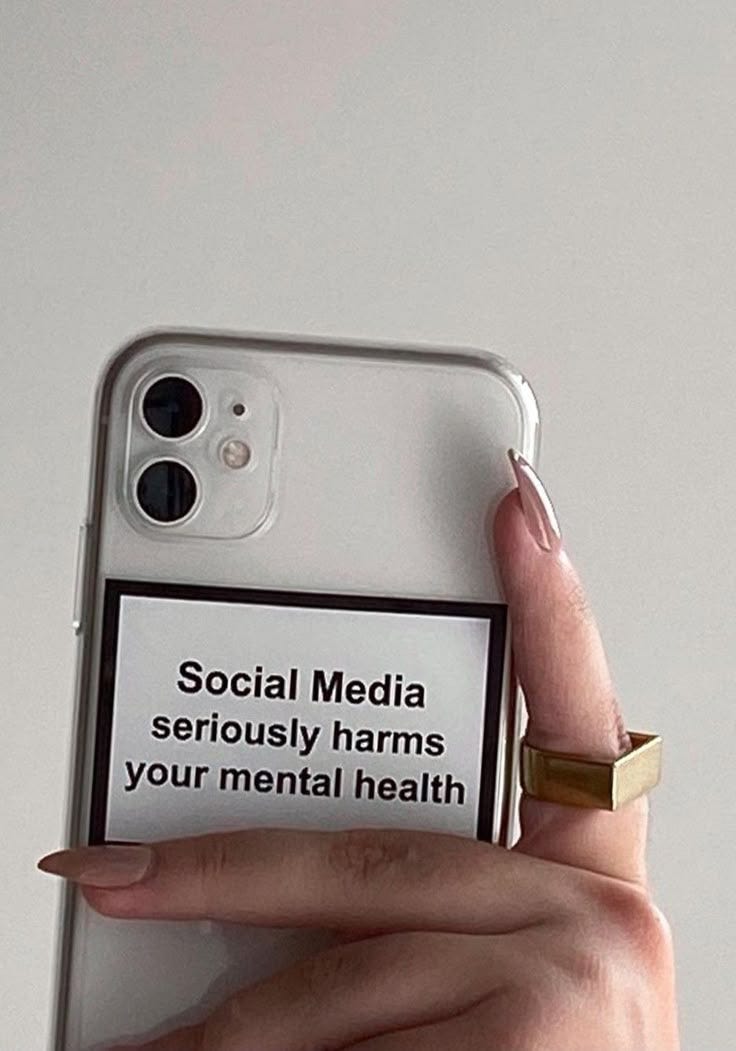 This may contain: a woman holding up her phone with the message social media seriously harms your mental health