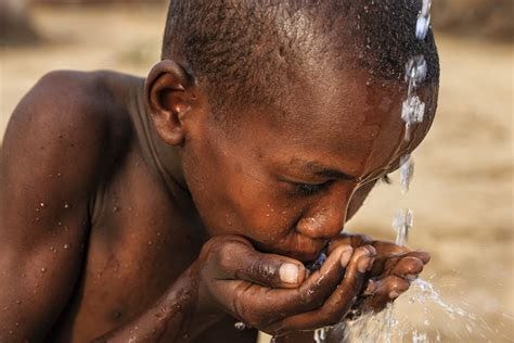 African young boy drinking fresh water on savanna, East Africa - USGLC African young boy drinking fresh water on savanna, East Africa - USGLC
