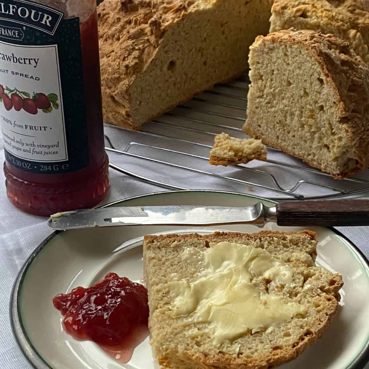 Fresh baked Soda Bread with butter and strawberry jam on a plate. Fresh baked Soda Bread with butter and strawberry jam on a plate.