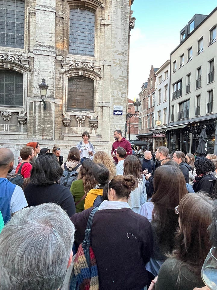 In the left-hand photo, a man and a woman are addressing a crowd of people in an outside space in Brussels next to a church and some bars. The woman is wearing a keffiyeh. In the right-hand photo, a heavy rock band are posing for the camera on a stage in a blue-light stage. A woman in a red dress holds the mic while two guitarists and a woman in a black dress stand beside her.