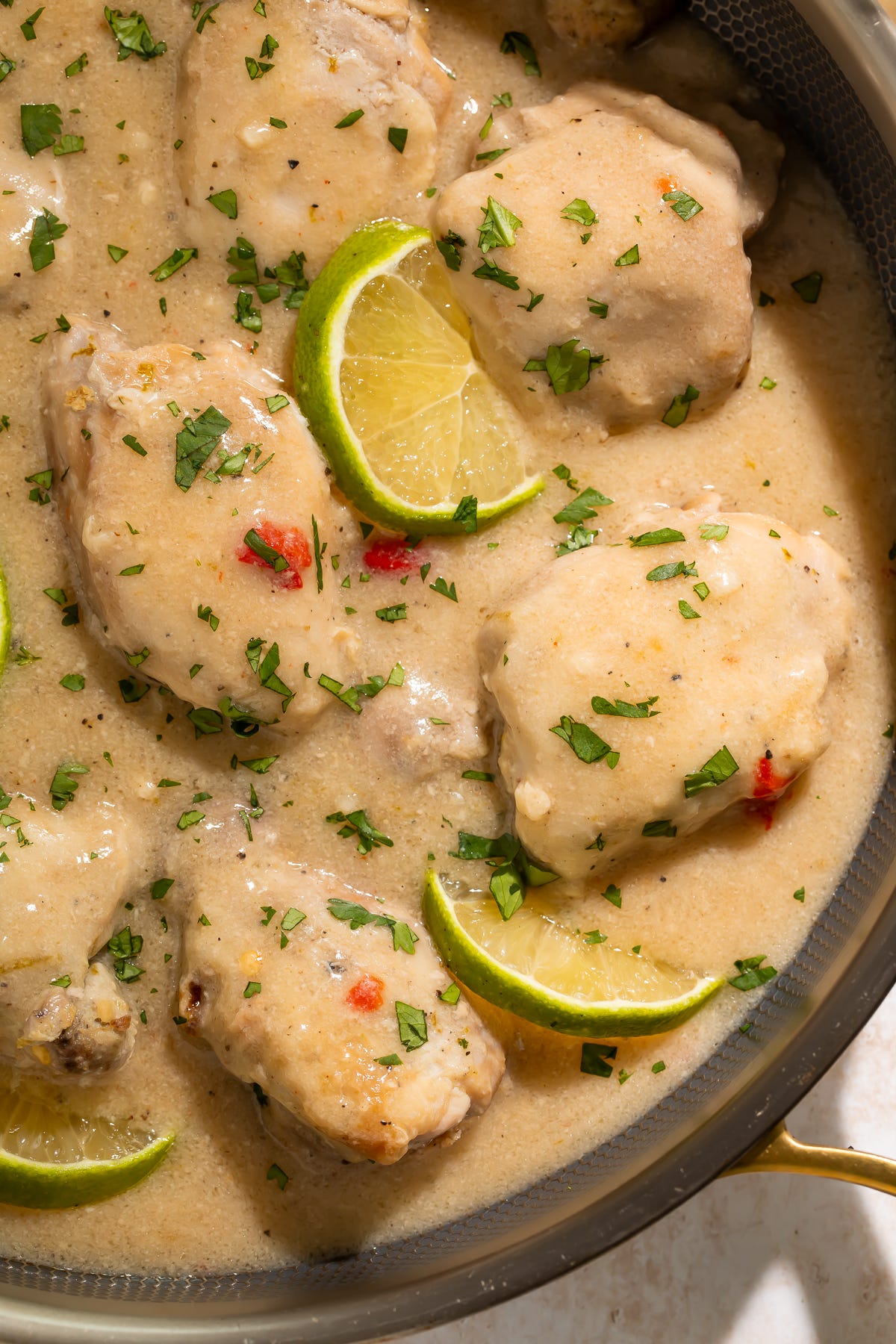 Slow cooker Chicken thighs in a coconut-lime sauce, with slices of lime, in a skillet Slow cooker Chicken thighs in a coconut-lime sauce, with slices of lime, in a skillet