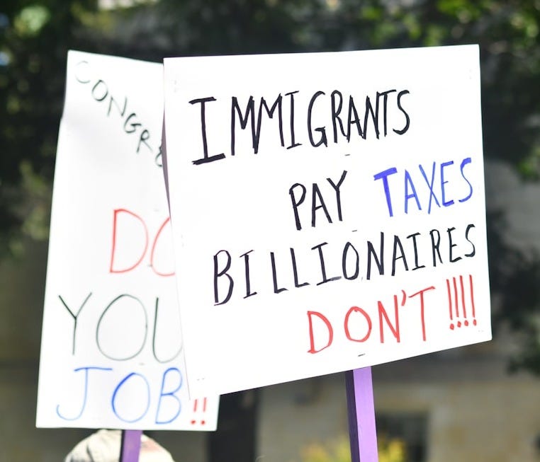 Protest signs about taxes and jobs Protest signs about taxes and jobs