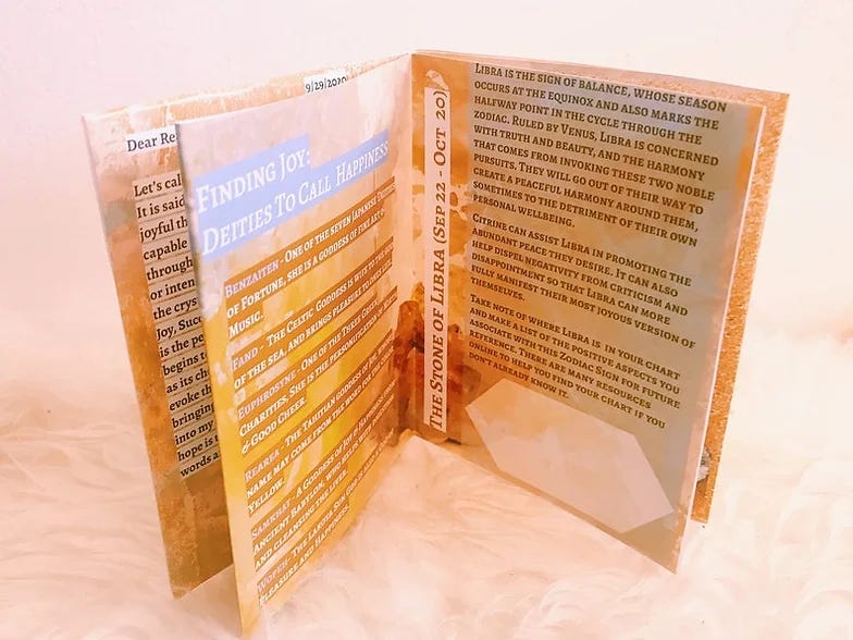 A yellow zine open to the middle with the headlines: Finding Joy- Deities to call Happiness and The Stone of Libra.