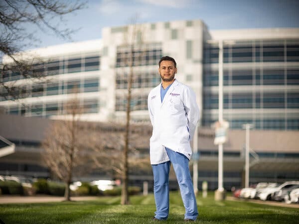 Faysal Alghoula, a 38-year-old pulmonologist from Libya, poses for a photo outside of Deaconess Gateway Hospital where he works in Newburgh, Ind.