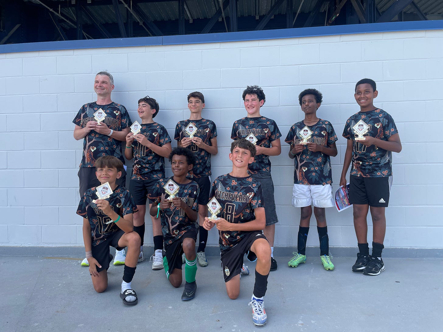 Cambridge United U14 boys team holding 4v4 prizes after winning the Revolution cup.