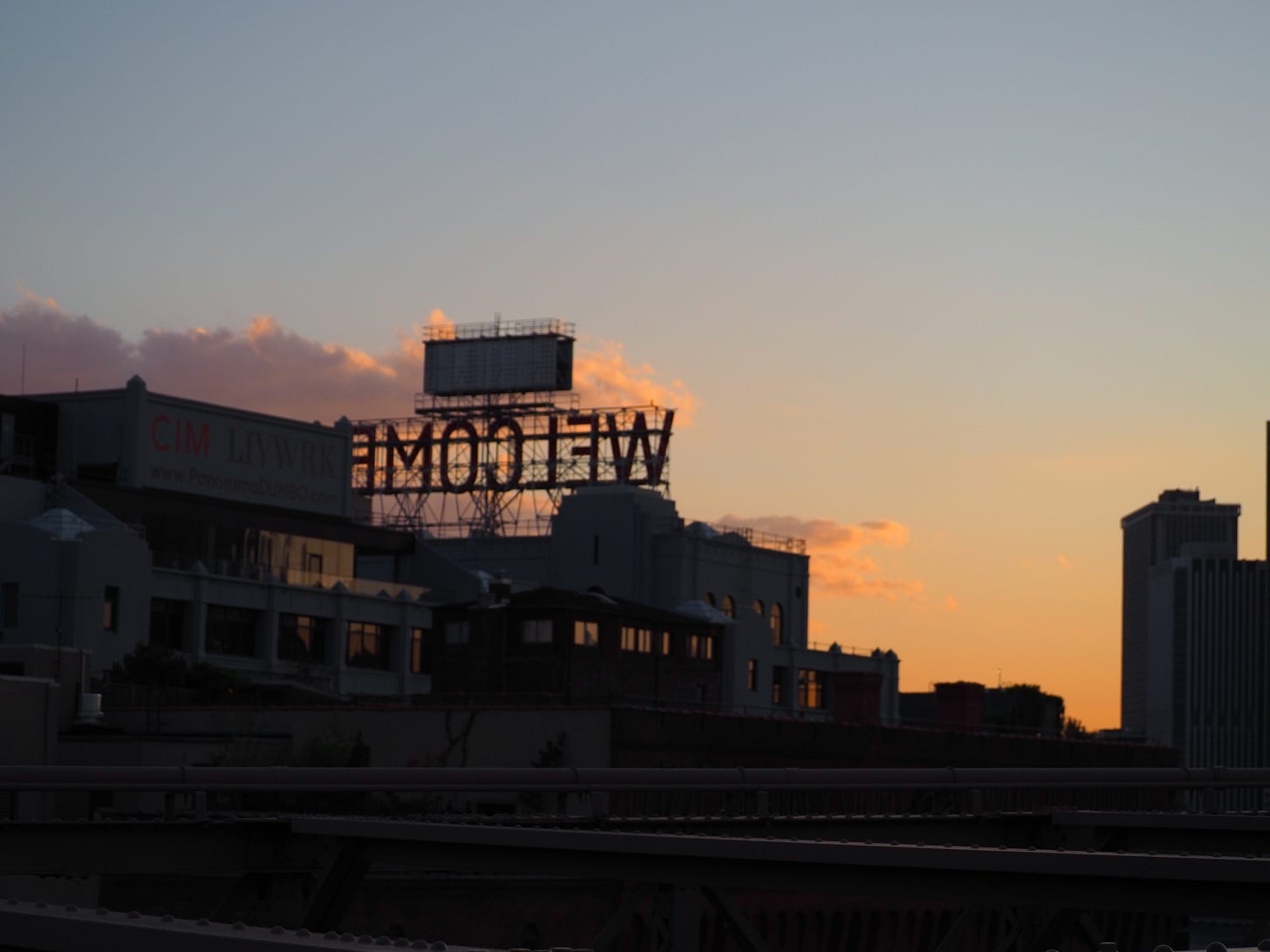 welcome sign near brooklyn bridge against the sunset
