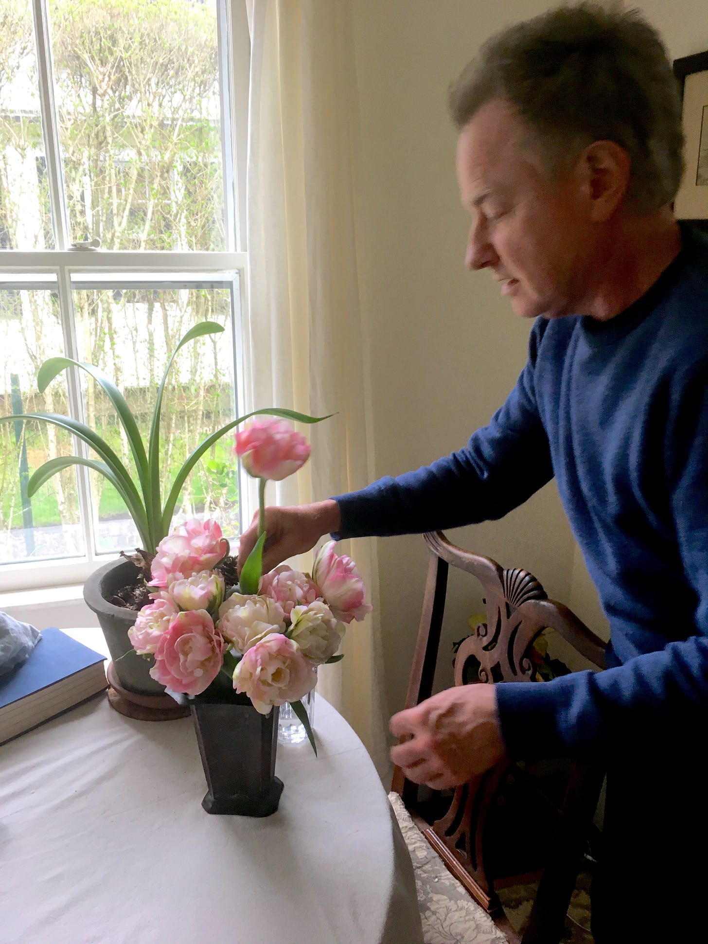 Nicholas Grimshaw before cancer diagnosis putting cut pink peonies into a vase at Pleasant Lane, East Hampton