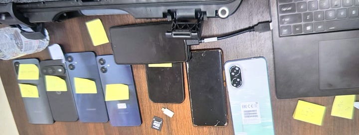 Dëshmia #1 – Paketime SIM: Kartela SIM dhe paketime aktivizimi të fotografuara si pjesë e inventarit, me kodet e sigurisë të redaktuara. | Dëshmia #2 – Harta dhe materiale të shtypura: Harta rajonale dhe dokumente letre të sekuestruara, që sugjerojnë planifikim lëvizjeje ose reference terreni. | Dëshmia #3 – Para dhe sende personale: Para të gatshme, dokumente dhe objekte personale të shtrira gjatë inventarizimit zyrtar. | Dëshmia #4 – Telefona dhe pajisje elektronike: Telefona të shumtë, karta memorie dhe pajisje të lidhura, të etiketuar si prova. | Dëshmia #5 – Mjete teknike dhe mjete ndihmëse: Kabllo, module elektronike dhe mjete të tjera ndihmëse, që tejkalojnë përdorimin bazik personal.