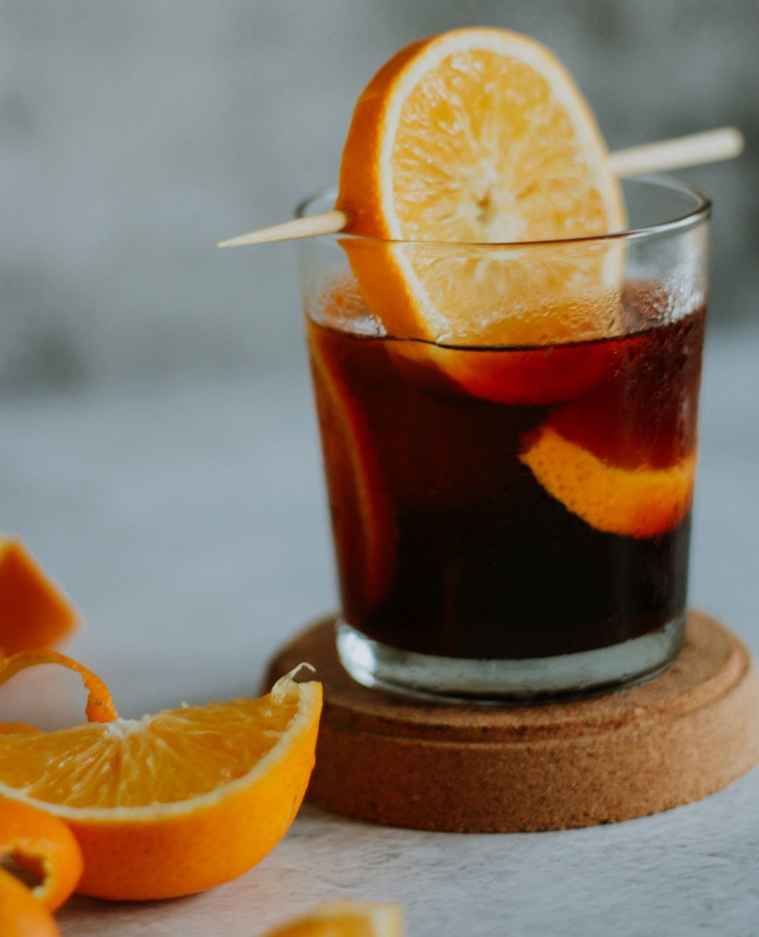 clear drinking glass with brown liquid and sliced orange fruit clear drinking glass with brown liquid and sliced orange fruit
