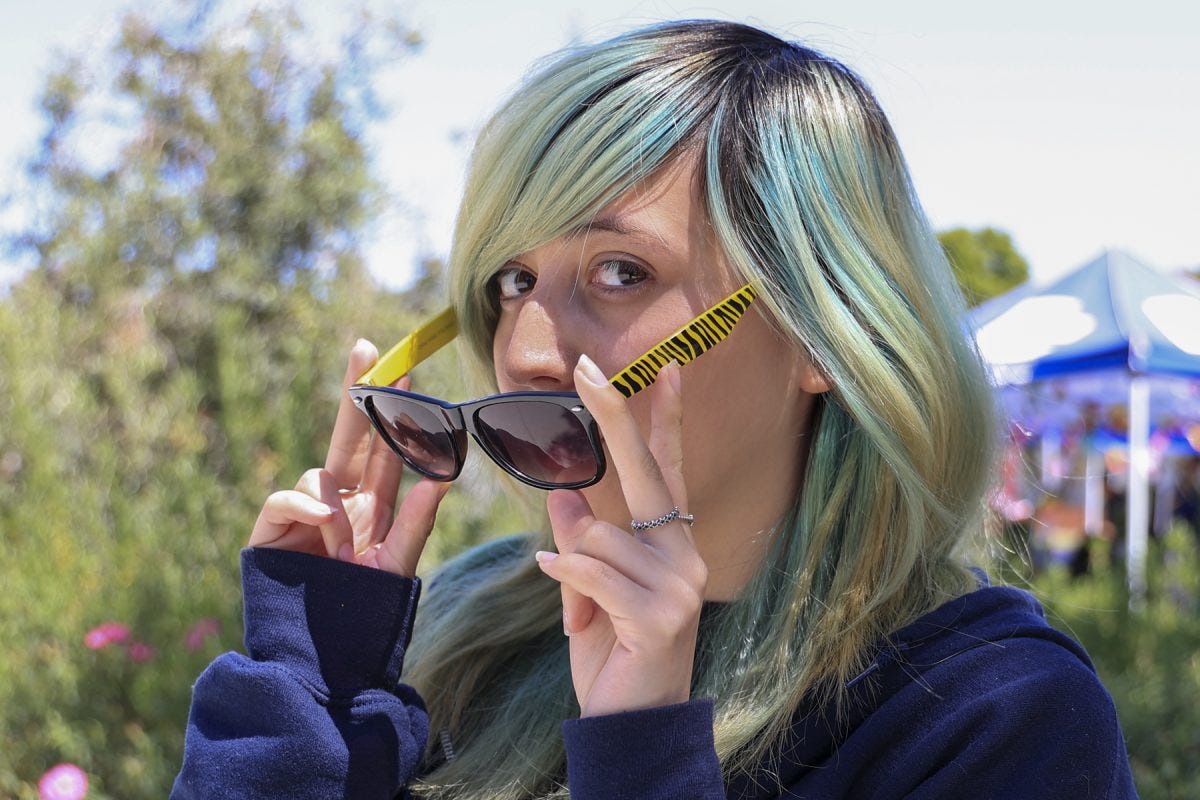 Marcie Macias, 21, a studio arts major, got her sunglasses from Metal Wings Rock Accessories, a seller at the Roadium Open Air Market in Torrance. Macias said she is a fan of the striped design of the glasses and wears them every day. She likes to go thrifting for outfit pieces and accessories. (Eddy Cermeno | Warrior Life) Marcie Macias, 21, a studio arts major, got her sunglasses from Metal Wings Rock Accessories, a seller at the Roadium Open Air Market in Torrance. Macias said she is a fan of the striped design of the glasses and wears them every day. She likes to go thrifting for outfit pieces and accessories. (Eddy Cermeno | Warrior Life)