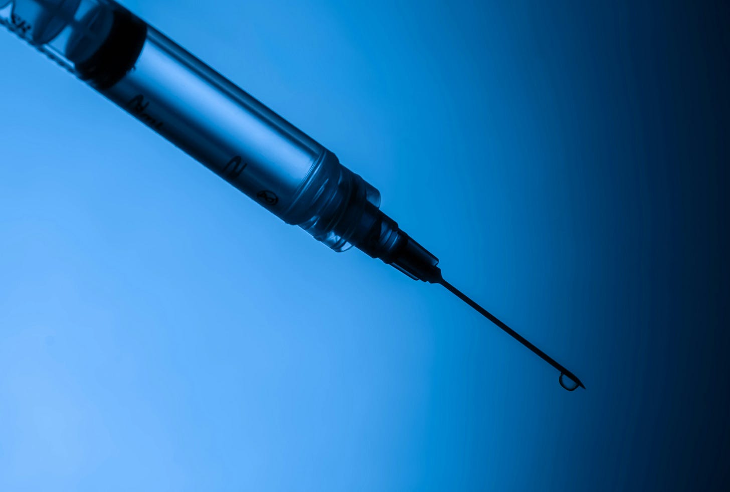 image of a syringe with a droplet on the needle