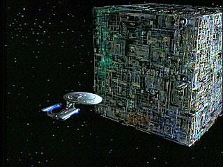 A Borg cubs with a Star Trek federation ship approaching A Borg cubs with a Star Trek federation ship approaching