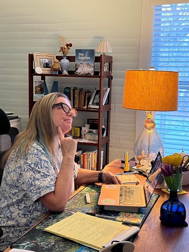 Two photos of Melora Fern sitting at her desk. On one she is looking at the screen through her glasses with her mouth open, in the other she has a finger on her chin and her head tilted up