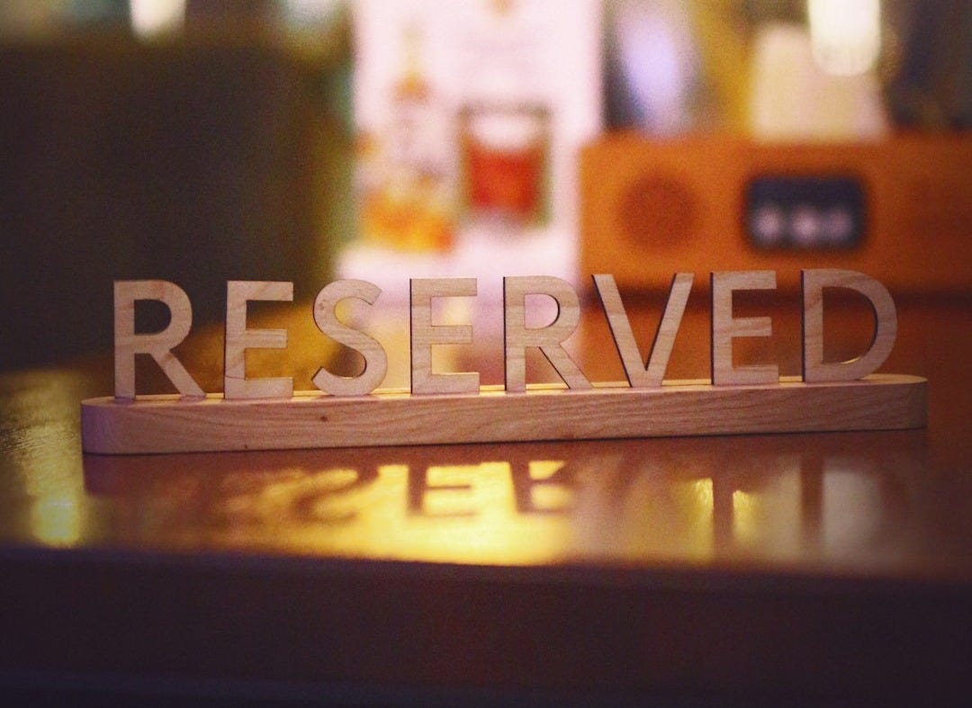 a wooden block that says reserved sitting on a table