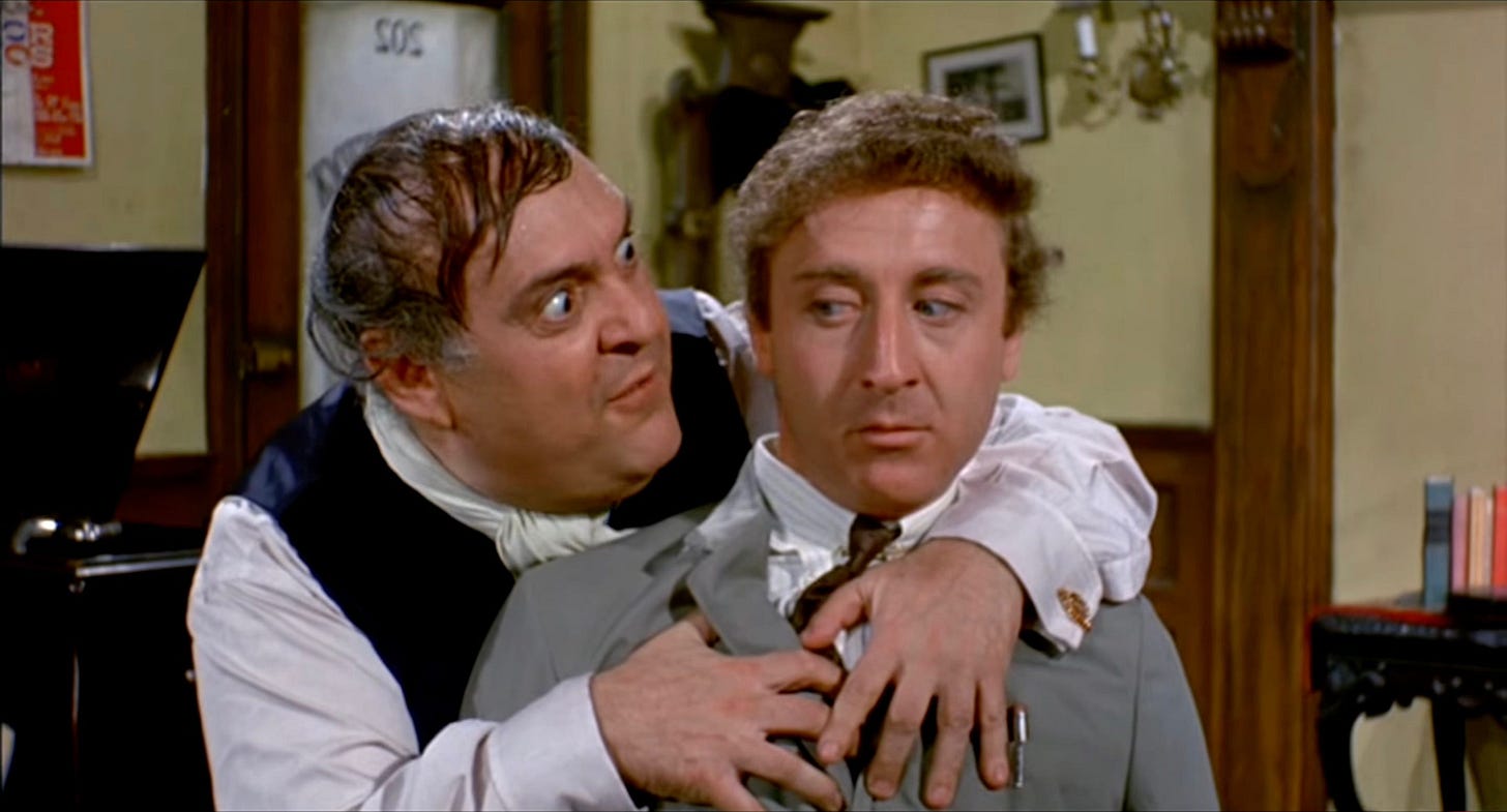Wild eyed Mostel hanging on a skeptical Wilder in a still from the producers